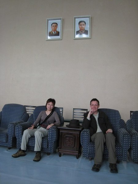 Fi and I sitting beneath pictures of the Great Leader and Dear Leader