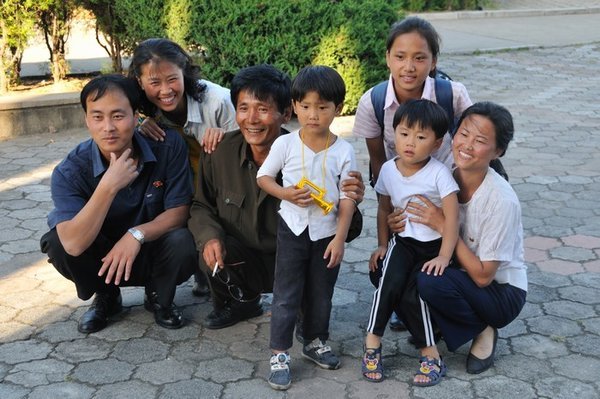 Family posing for a photo to a fellow foreigner - Mangyongdae Fun Fair, near Pyongyang, North Korea