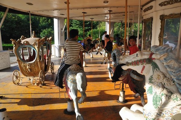 Riding the merry-go-round at the Mangyongdae Fun Fair - near Pyongyang, North Korea