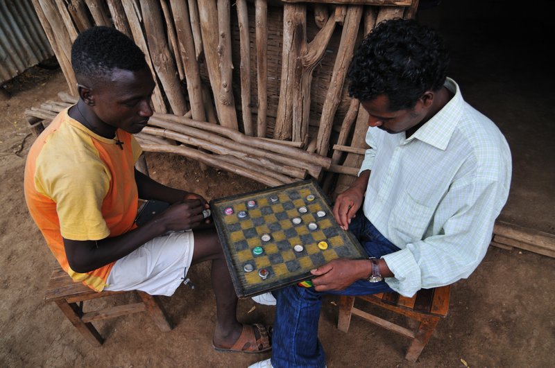 Men playing checkers in Omorate - Omo Valley, Ethiopia