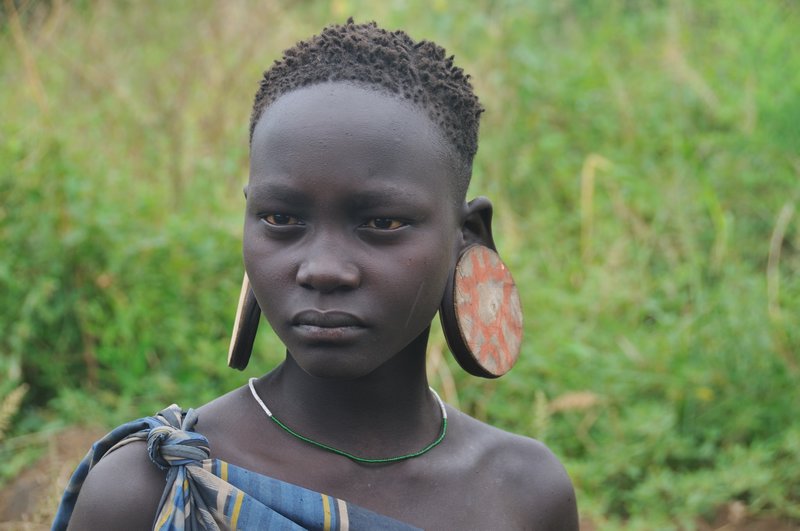 Mursi girl with large ear plates - Mago National Park, Omo Valley, Ethiopia