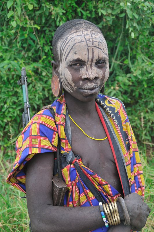 Mursi woman with gun - Mago National Park, Omo Valley, Ethiopia