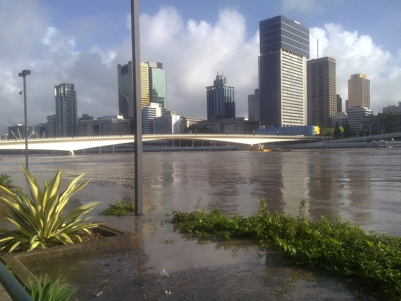 The swollen Brisbane River overwhelms the car park barricades in the previous photo - 12 Jan