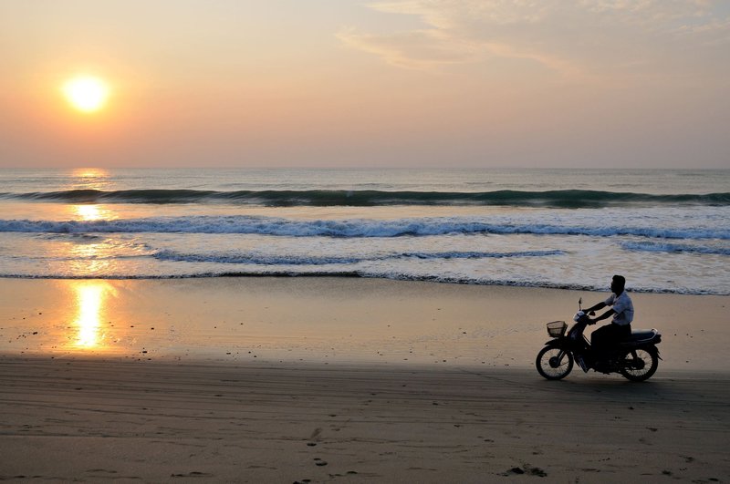 Motorcyclist near sunset - Ngwe Saung, Myanmar