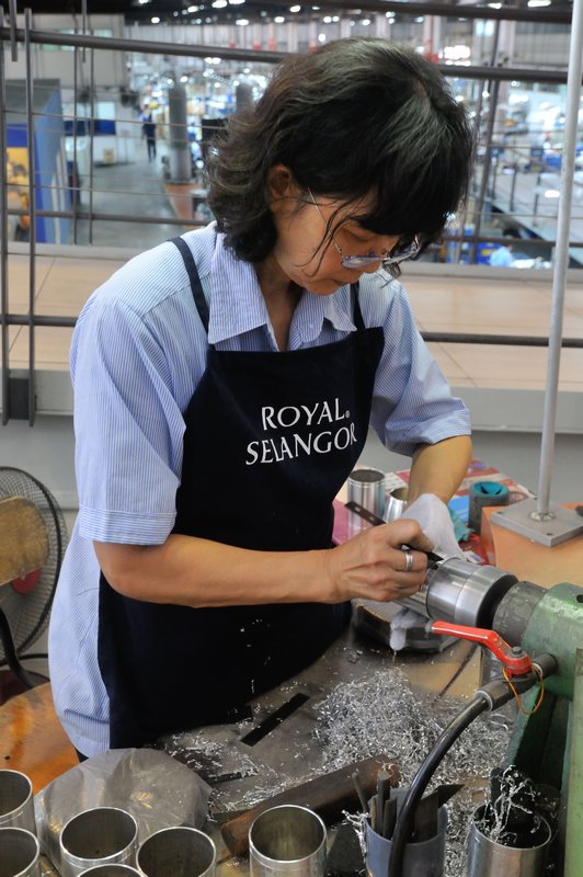 Employee smooths pewter at the Royal Selangor Visitor Centre, Selangor, Malaysia