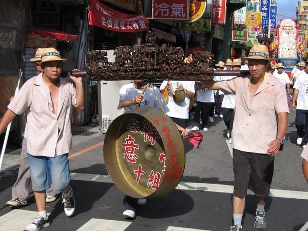 You'd look this way too if you had to carry this heavy gong in the hot sun