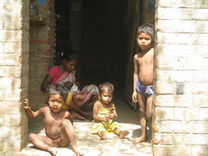 Women with 3 children in entrance to house