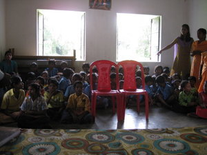 Children sitting on floor of one room school