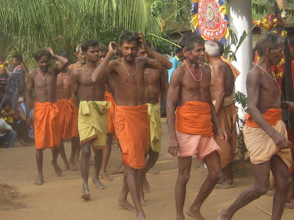 Men trying to get dirt out of hair as they circle the temple