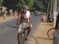 Man bicyclilng in a white dhoti