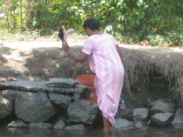 Woman washing clothes in Backwater community