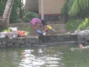 2 kids washing dishes in backwater channels