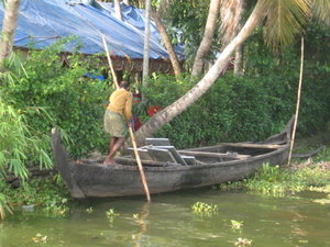 Man poling the boat across the backwaters