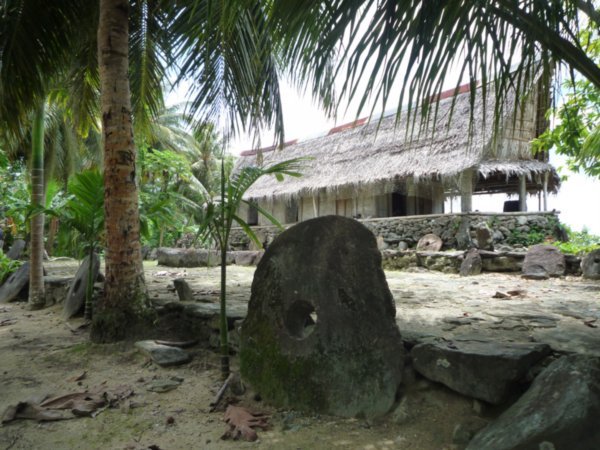 Mennenes hus med steinpengebank i en landsby på Yap
