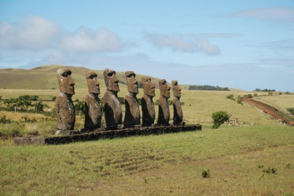 7 moaier som står litt inne i landet og ser utover mot sjøen
