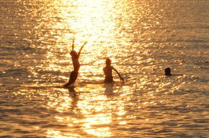 Kids playing in the sea at sunset, Lovina