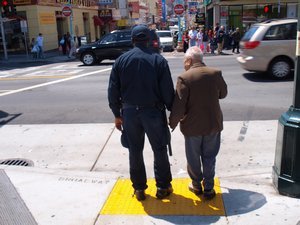 African-American cop helping Chinese-American senior across the street