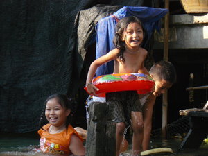 kids playing in the canal at the floating market