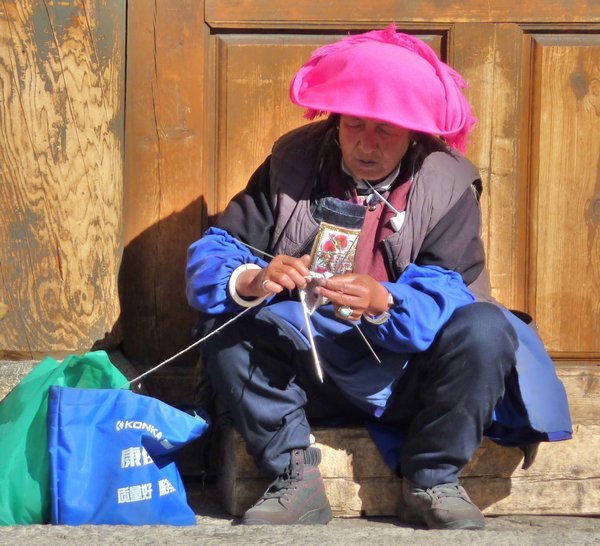 A lady on the street knittin