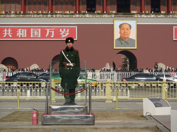 A soldier stands diligently whilst Mao looks on