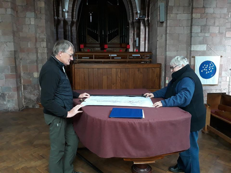 Bill and Penny unscrolling the 1578 map of the town of Crediton