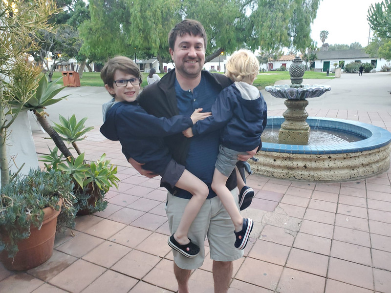Evan carrying Connor and Logan at the San DIego Zoo after their legs wore out