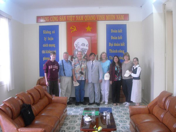 Our hosts pose for pictures with our group in the reception room next to the dining hall in the main building