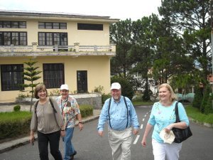Ruth, Johnny, Bob, and Barb arrive at the Dalat School campus climbing the long hill