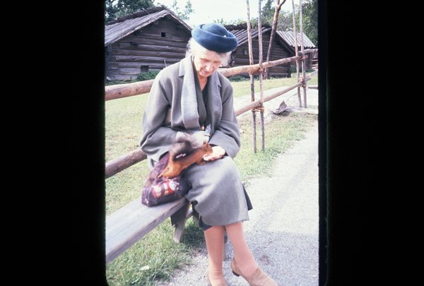Grandmother feeding squirrel at Skansen Open Air Museum