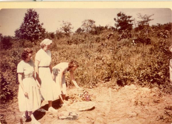 Missionaries laying flowers at the Johnsons' grave