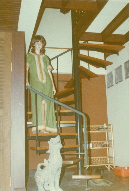 Linda on spiral stairs from dining room to upstairs living room