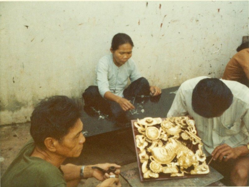 Artisans crafting a gilded plaque