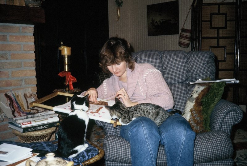 Linda trying to cross stitch while Priscilla and Camilla look on