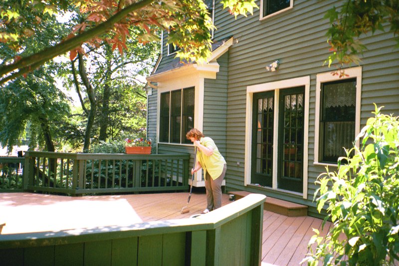 Linda sweeping our back deck