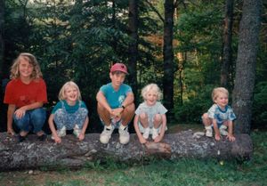 Alyssa, Tamara, Brendan, Rosanna, and Will perched on a log at camp