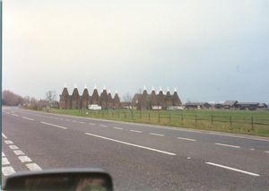 Oast houses for drying hops in the Kent countryside as seen from the motorway on the way to Dover