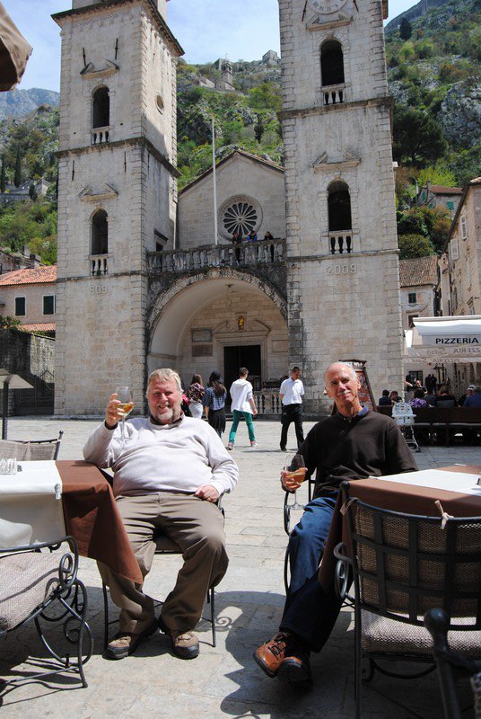 Bob an Mike savoring wine in front of the Cathedral of St Tryphone in Kotor