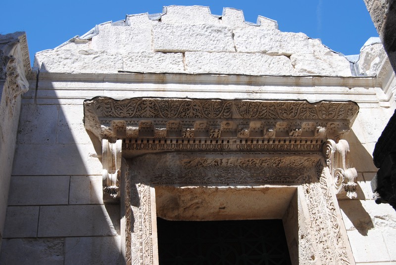 Detailed stone carving over the entrance to the Temple of Jupiter