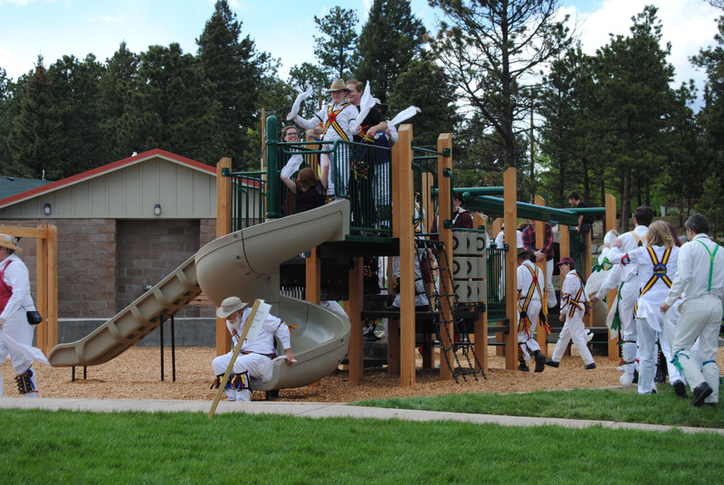 Morris Dancers lining up to slide in the childrens' playground (limited to ages 5-12, but who cares) in Memorial Park
