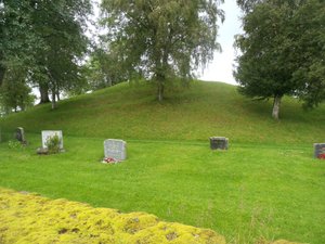 Old Viking chieftain burial mound with more recent graves in the foreground