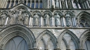 Nidaros Cathedral fascade with St. James in the middle with pilgrims hat and walking stick
