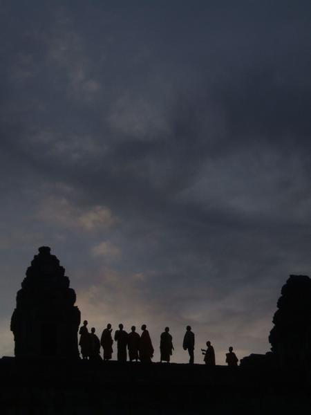 monks watch the sunset at Phnom Bakheng 