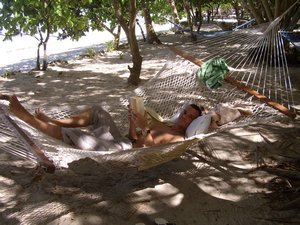 Matt chilling out in a hammock with a good book at White Sandy Beach Resort
