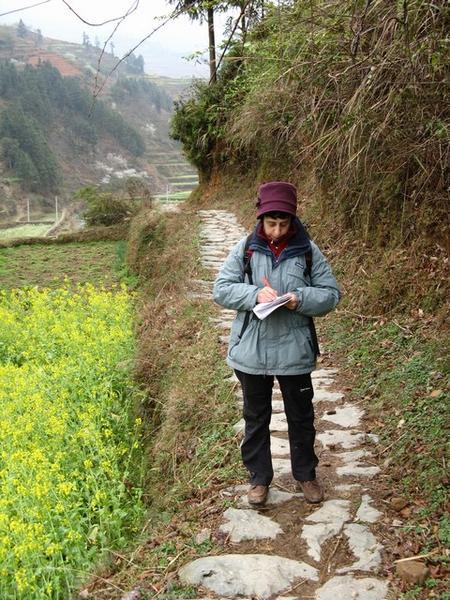 Ria met onafscheidelijk schriftje in actie in de heuvels rond Zhaoxing.