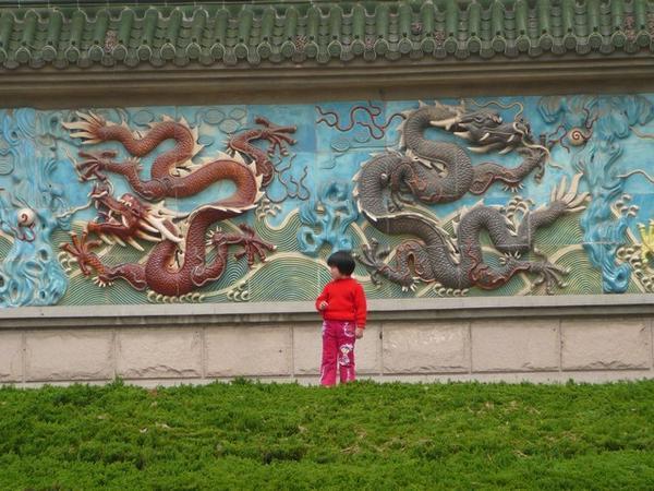 Meisje bij de drakenmuur in het Xihui park.