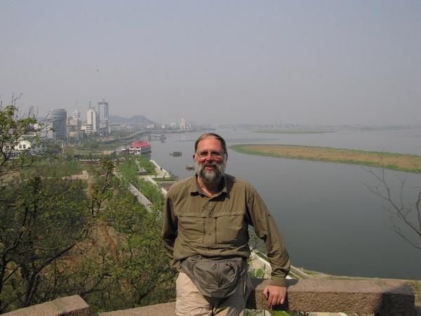 Wim is al boven. Op de achtergrond zicht op Zhenjiang en de rivier.