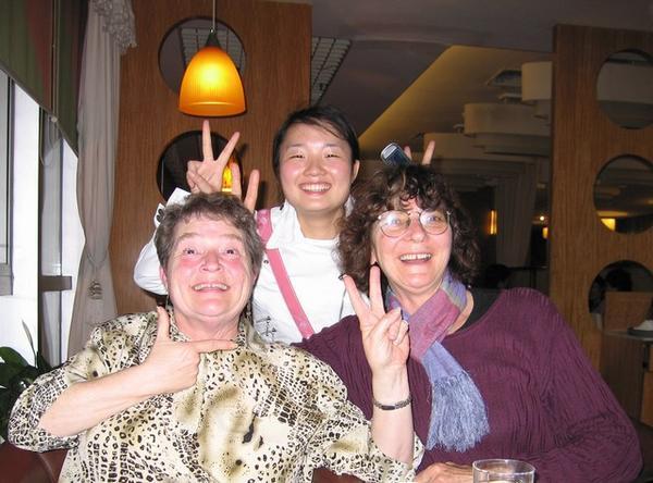 Sympathieke gastvrouwen: Shirley (links), Helen (rechts) en Stephanie (staande) met de typisch Chinese fotogroet.