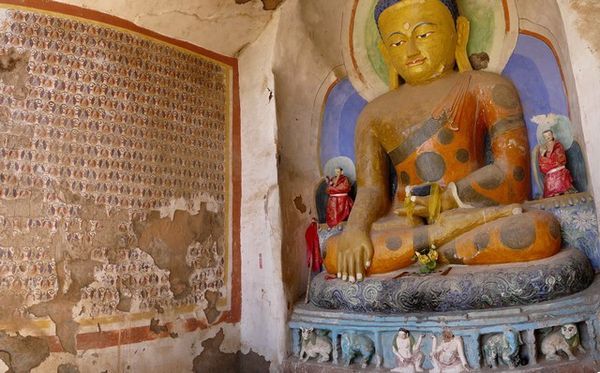 Kleine grot met een nieuwe grote en vele oude mini-Boeddha's.