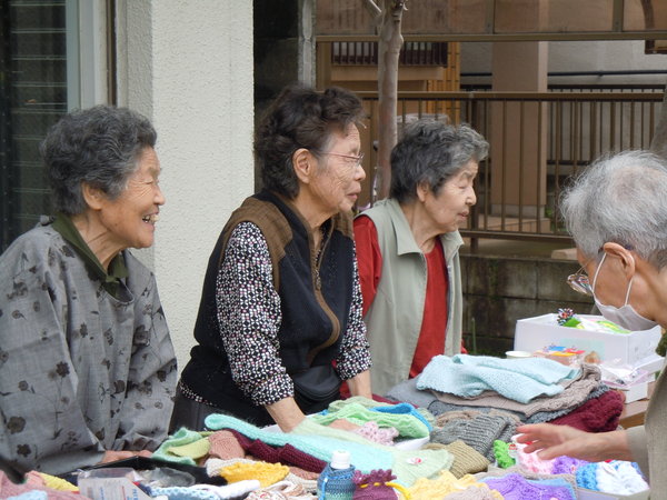 Ladies selling handknit baby clothes