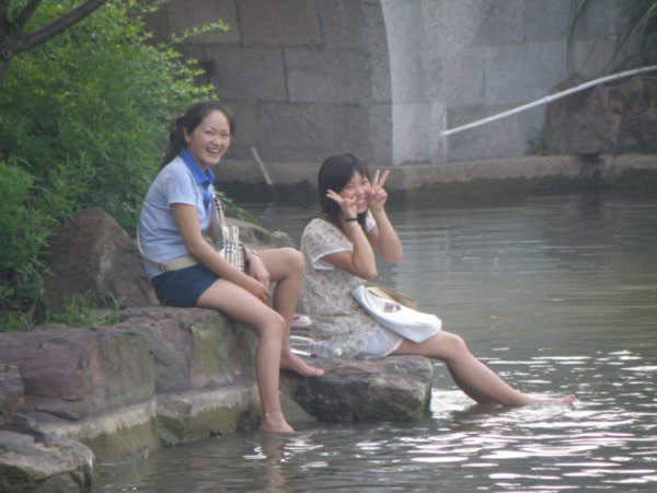Chinese girls relaxing along lake